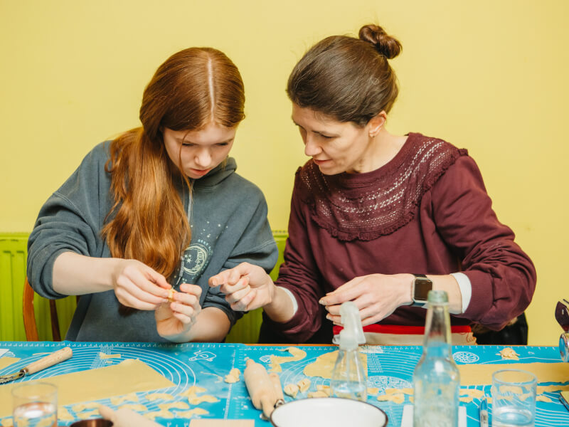Daughter and mother making pasta together